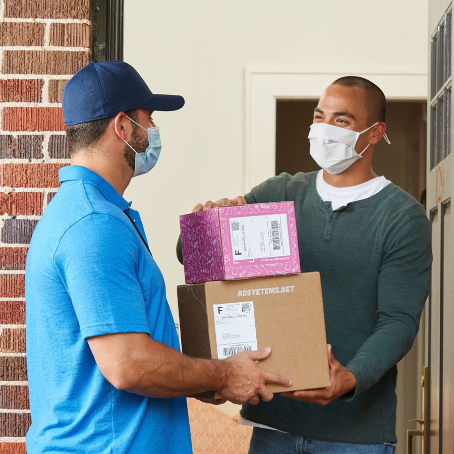 Man receiving packages at front door from deliveryman 