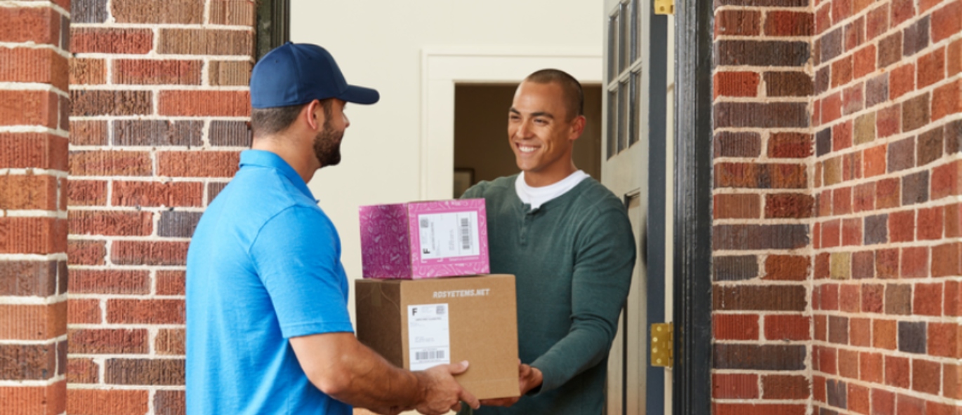 Man receiving packages at front door from deliveryman